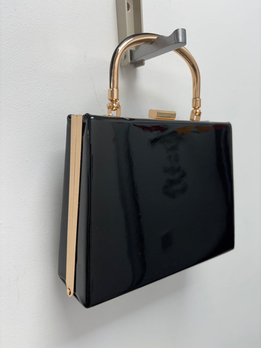 Black patent hand bag with gold handle